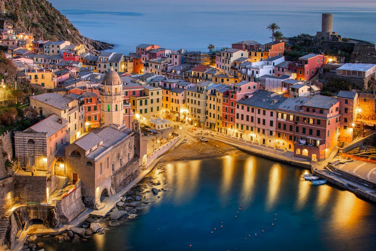 Vernazza village in Cinque Terre at twilight, with colourful houses stacked above the harbour