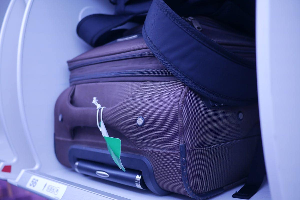 Hand luggage stored in an airplane overhead compartment