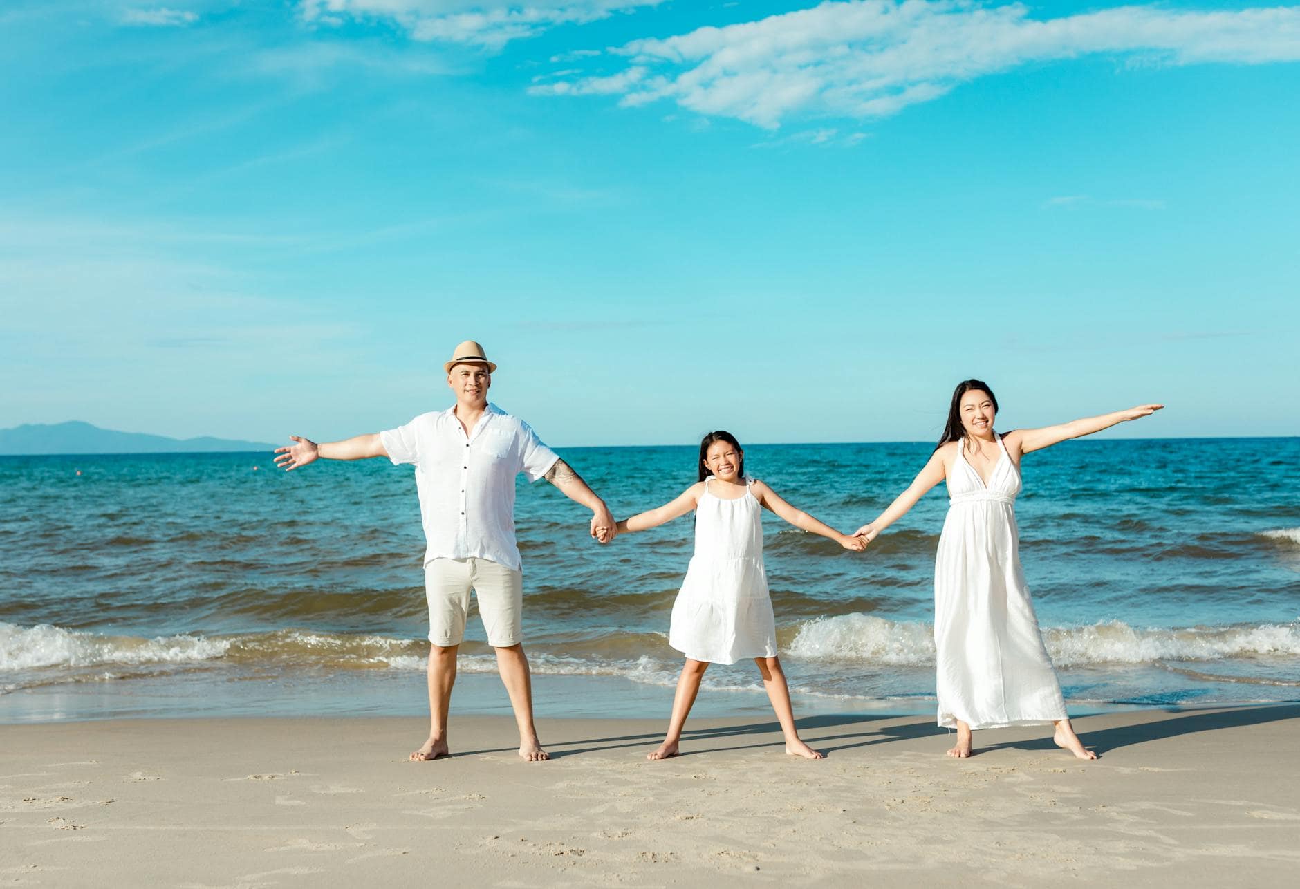 Family holding hands on a sunny beach on a TUI package holiday