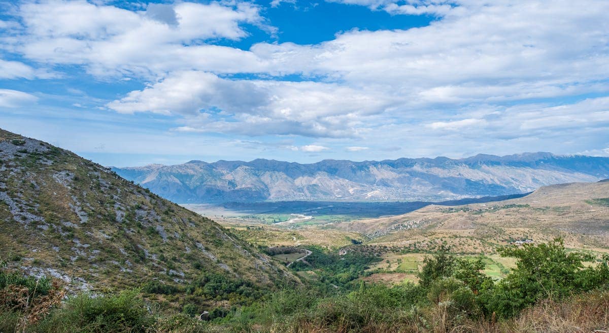 Panoramic view of Albanian countryside with winding road through mountain valley