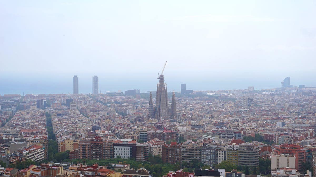 Aerial view of Barcelona at dusk showing the urban grid and Mediterranean coastline, Catalonia, Spain