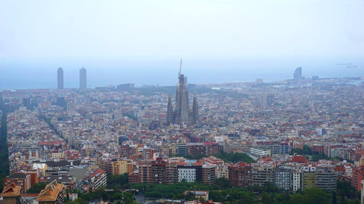 Aerial bird's eye view of Barcelona's city blocks and the Mediterranean coast, Catalonia, Spain