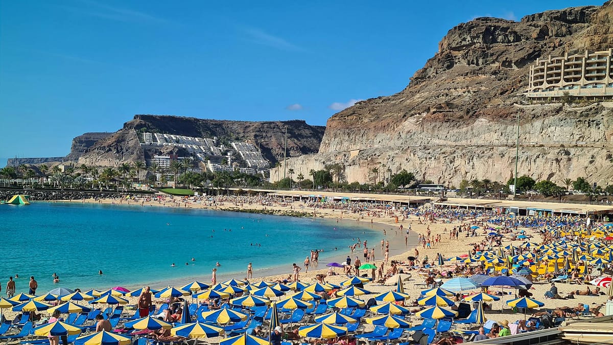 A vibrant beach in the Canary Islands on a sunny day with families enjoying the sunshine
