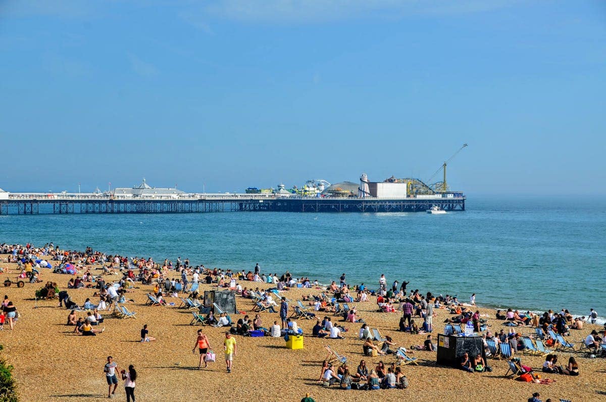 Brighton beach with the pier in the background on a sunny day, a popular UK school holiday destination