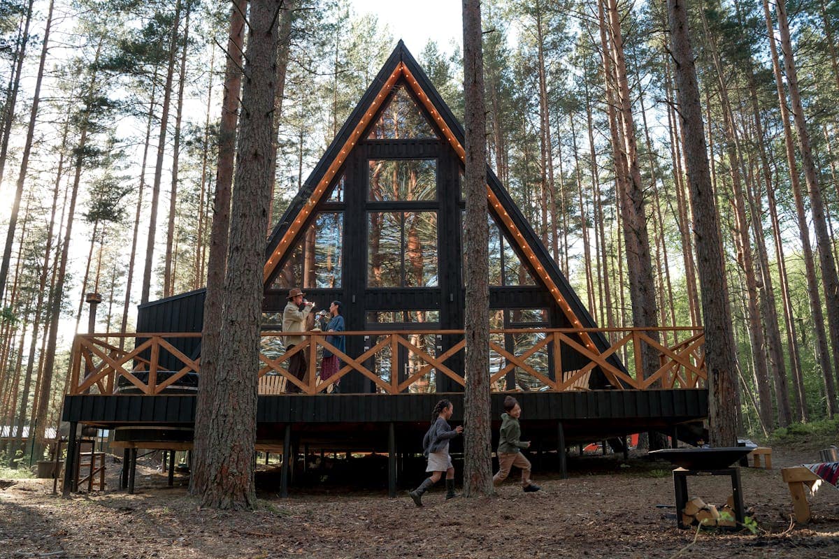 A family relaxing outside a woodland cabin at a UK self-catering holiday park