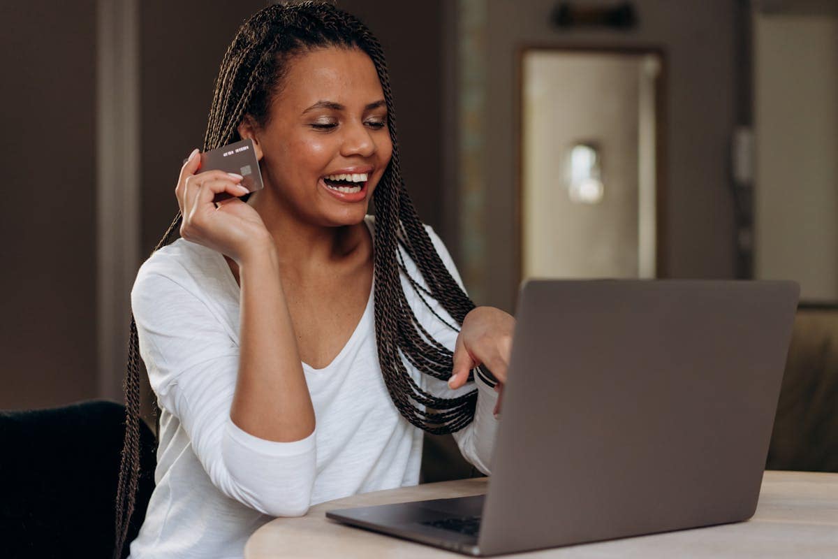Woman booking a flight online with a credit card and laptop
