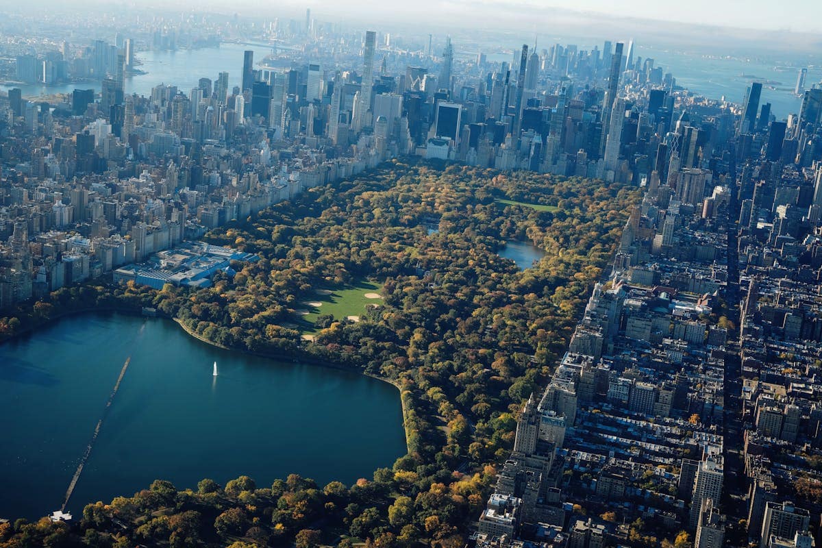 Aerial view of Central Park reservoir surrounded by autumn foliage and the Manhattan skyline