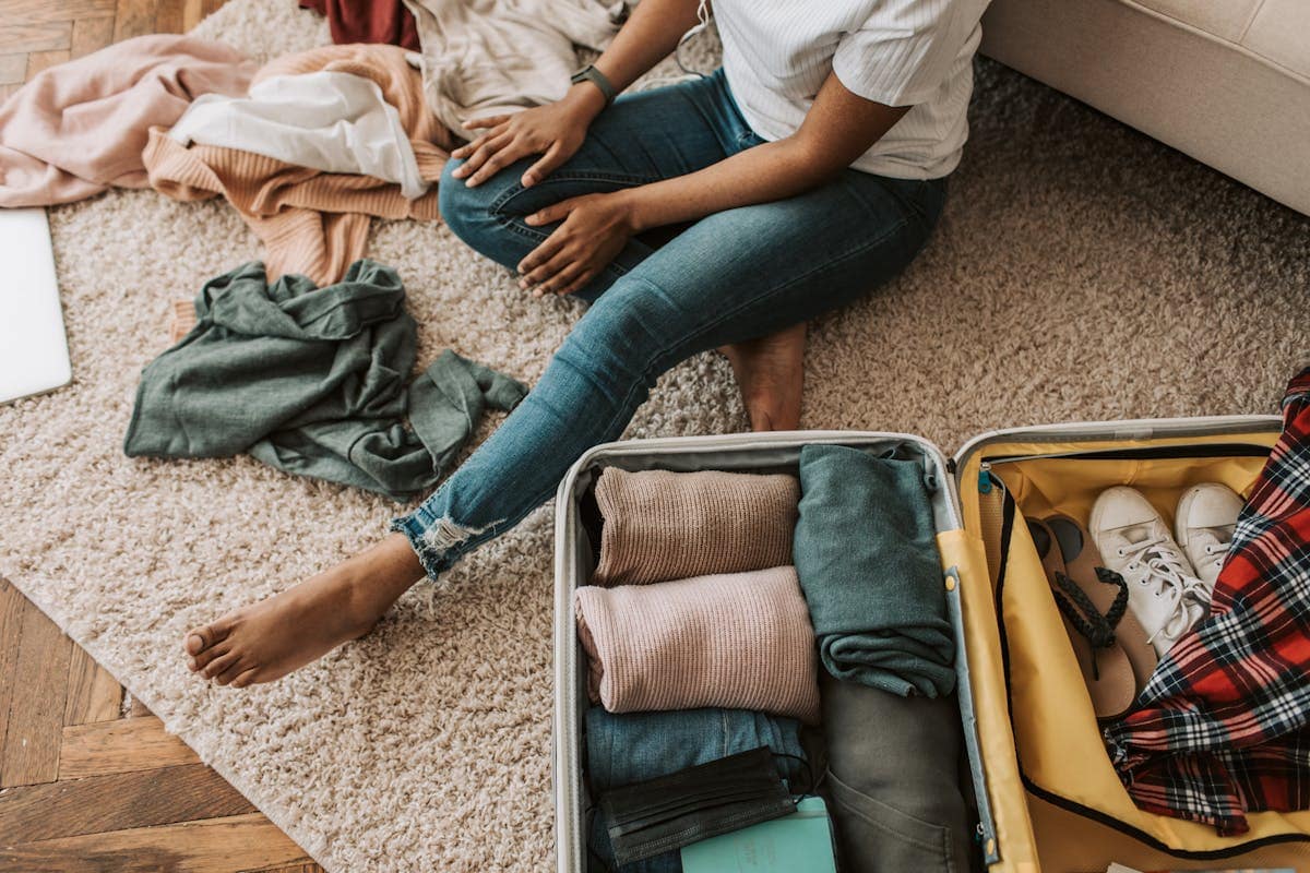Woman packing a cabin bag for a Ryanair flight, folding clothes into a small suitcase
