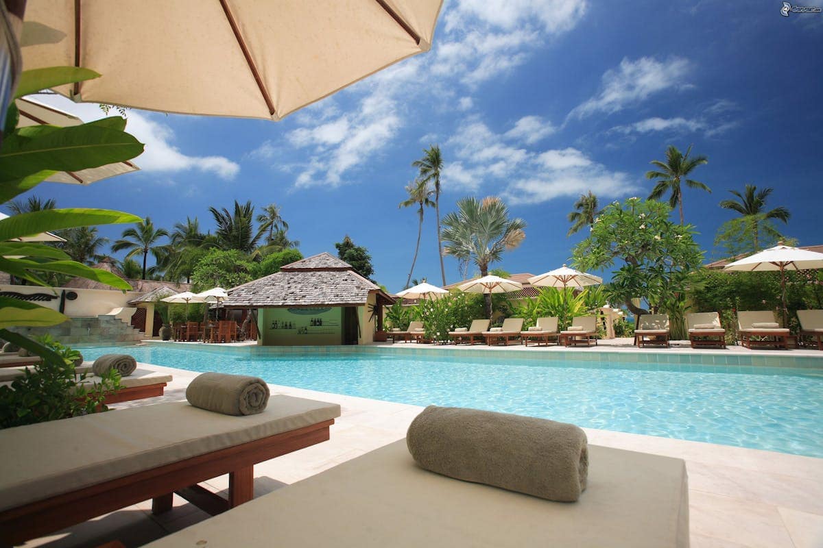 Luxury tropical resort pool with sun loungers and palm trees, BA Holidays package destinations