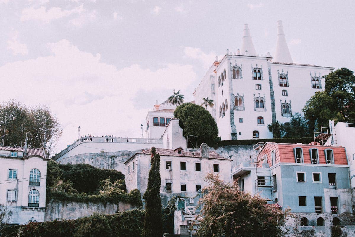 Sintra National Palace rising above lush trees and colourful buildings