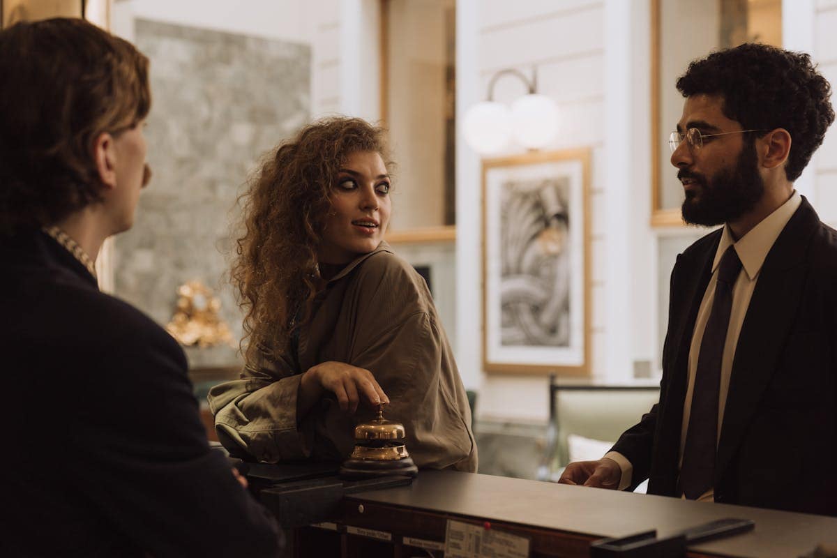 A family at a hotel reception desk checking in during school holidays