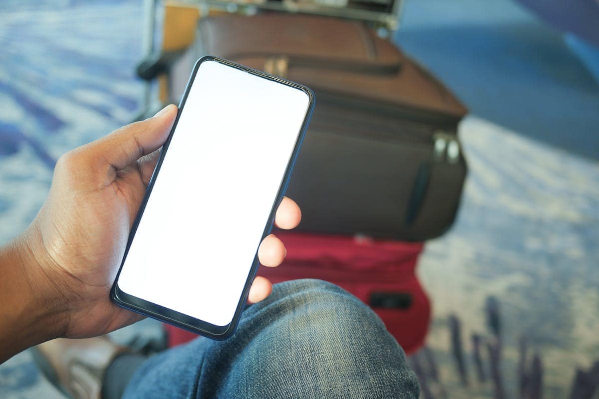 Traveller checking flight prices and alerts on a smartphone at the airport