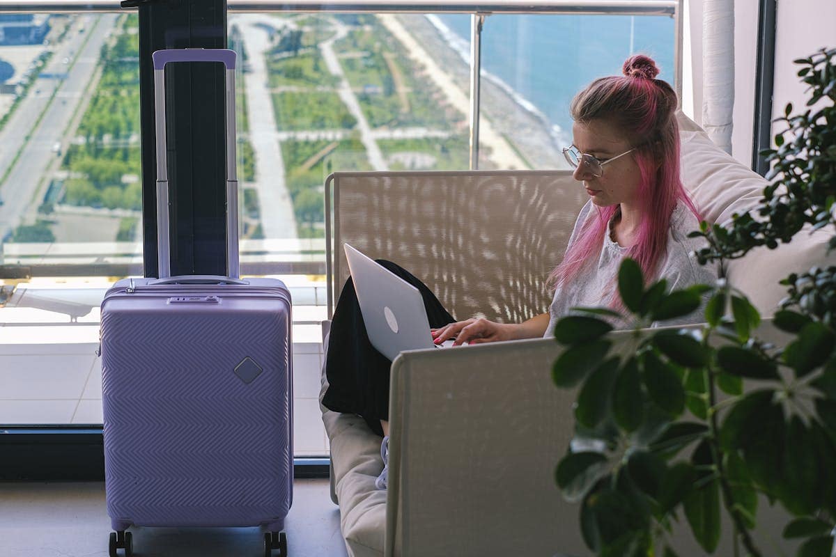 Woman using a laptop in a hotel room to browse and compare holiday deals online