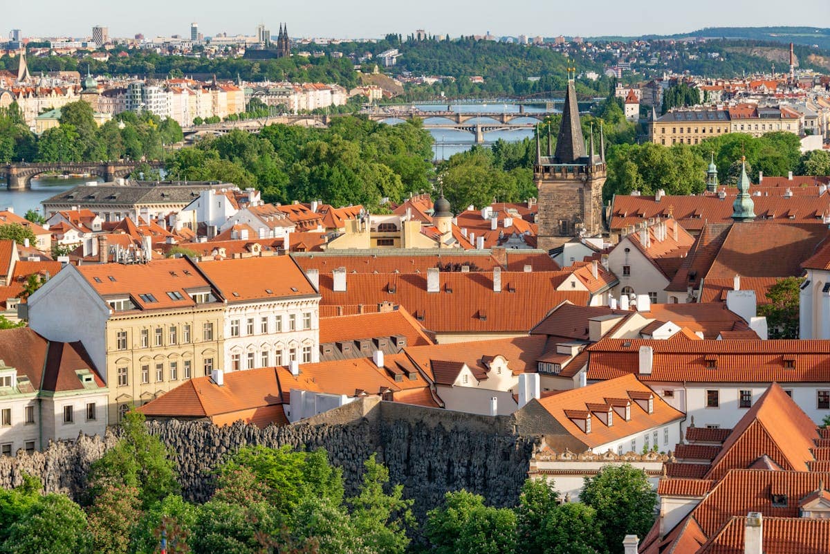 Panoramic view of Prague with red rooftops, Gothic spires and the Vltava river