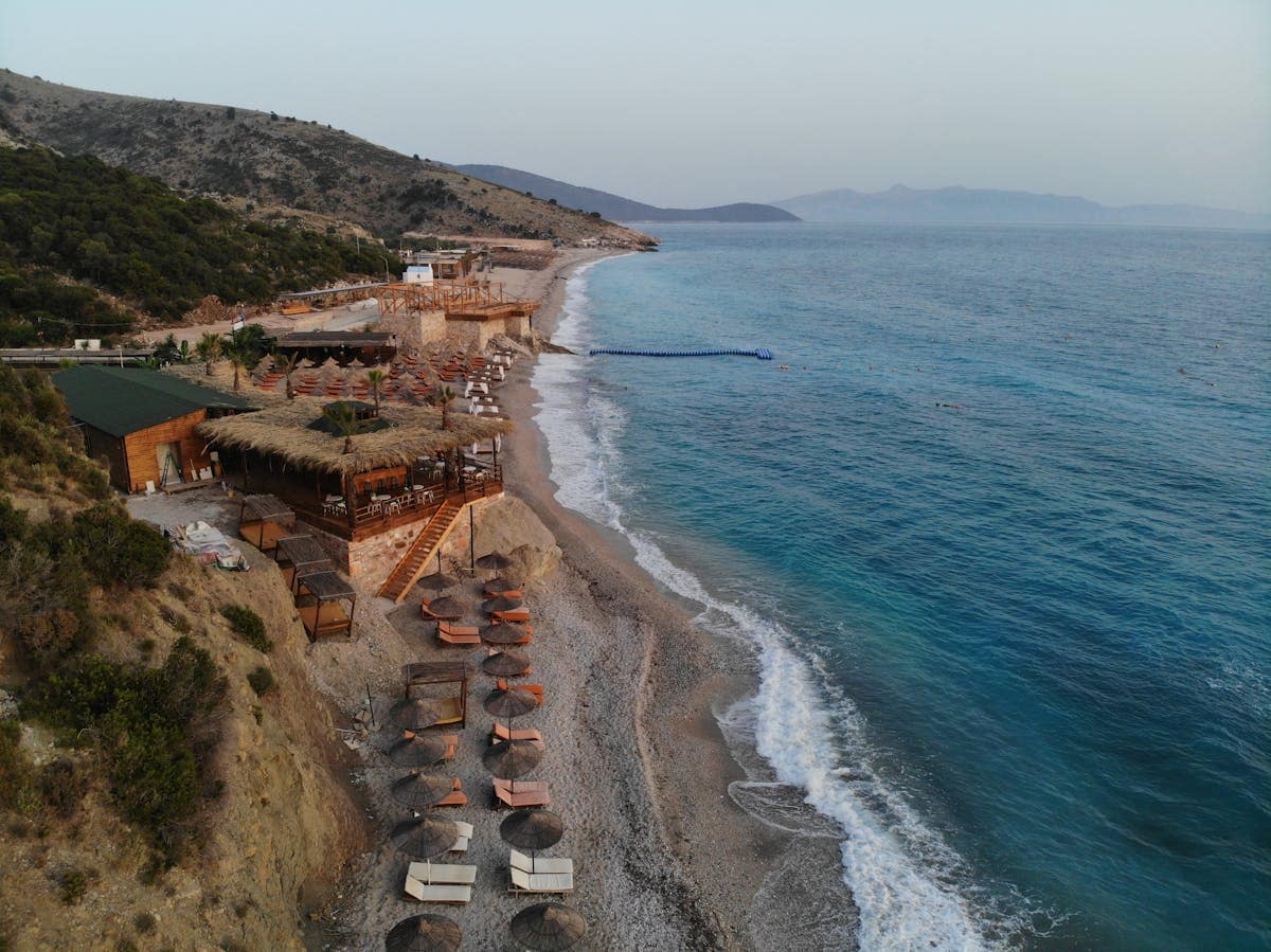 Aerial view of the Albanian Riviera beach resort with turquoise sea and hillside village