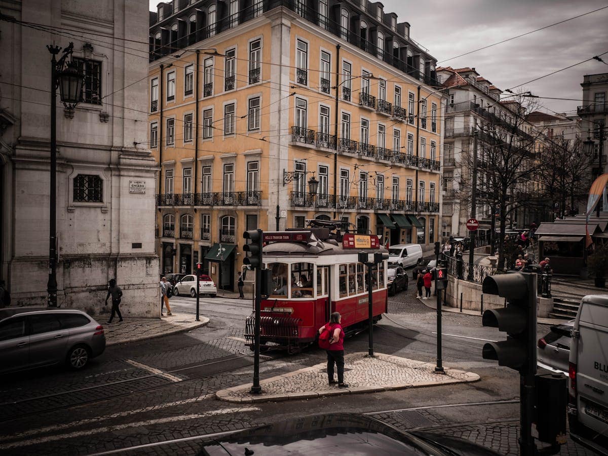 Historic yellow tram on a cobbled Lisbon street, one of the city's iconic modes of transport