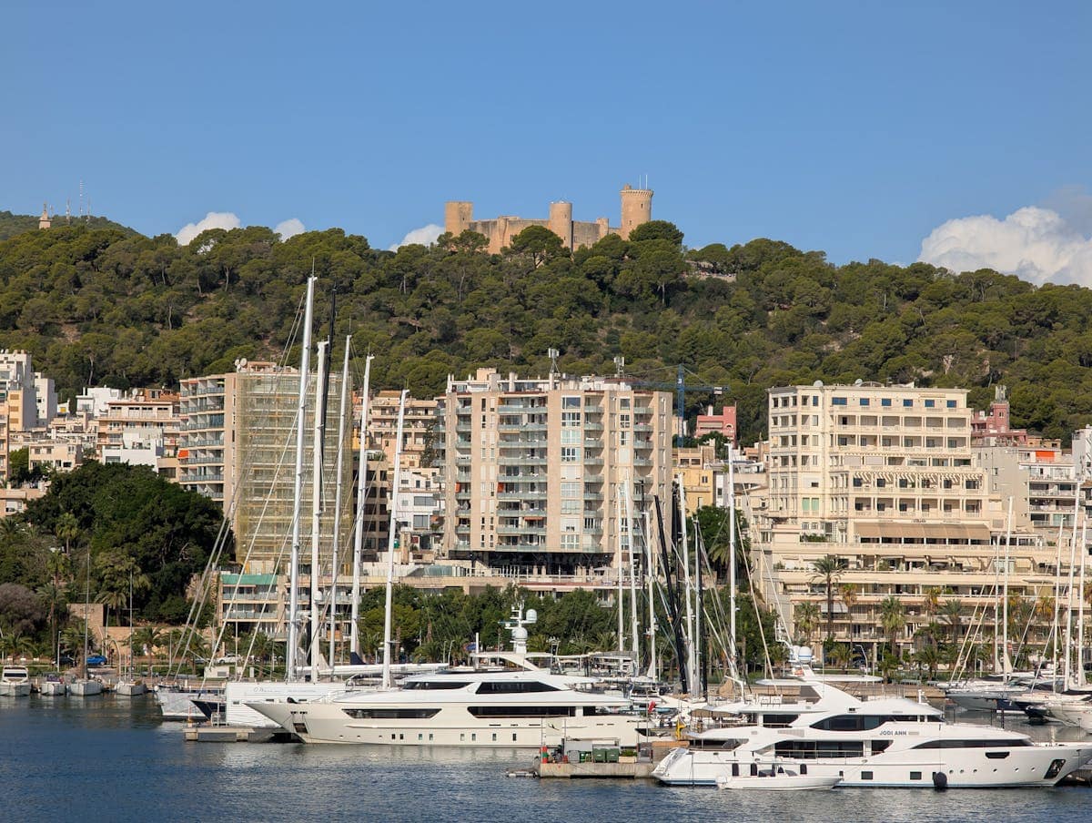 Palma harbour with boats and Bellver Castle on the hilltop, Majorca