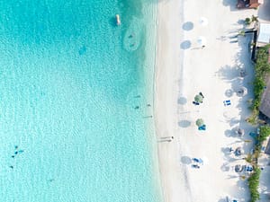 Aerial view of a white sand Caribbean beach with clear blue water