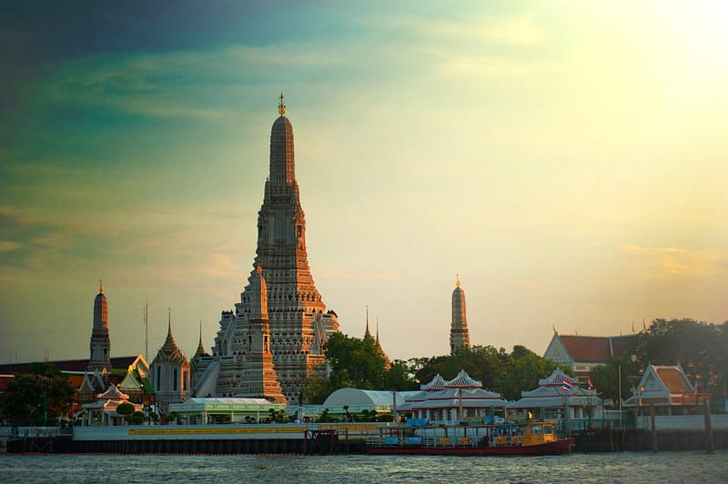 Wat Arun temple reflected in the Chao Phraya River at sunset, Bangkok Thailand