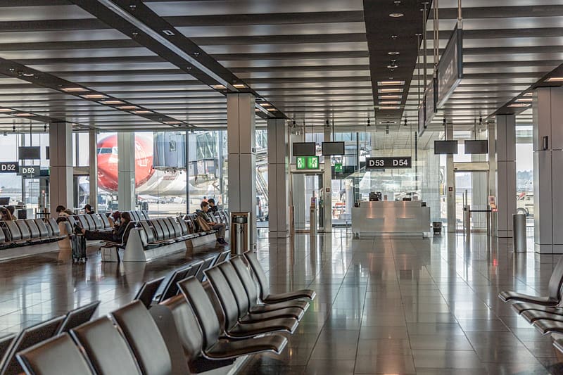 Modern airport terminal with departure gates and aircraft visible through glass windows