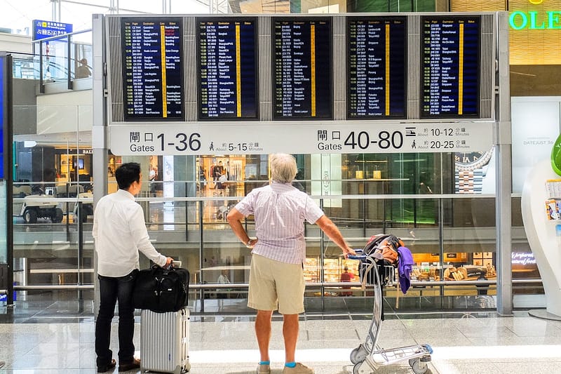 Passengers looking at airport departure board