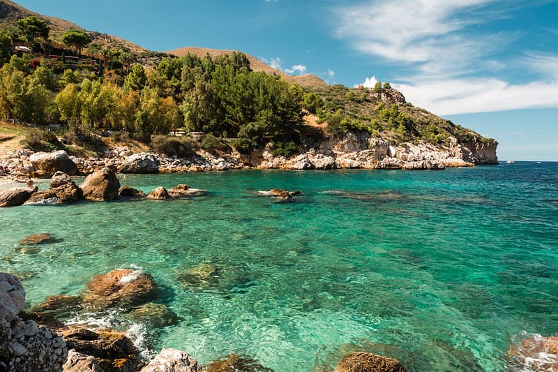 Clear turquoise water at a rocky beach cove in Sicily, Italy