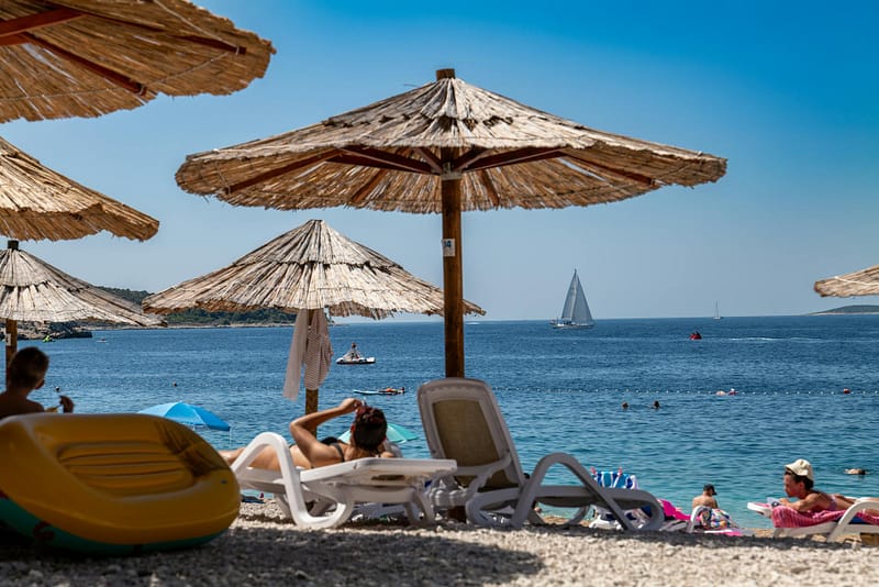 Sunbeds and straw umbrellas on a sunny beach — make the most of your annual leave